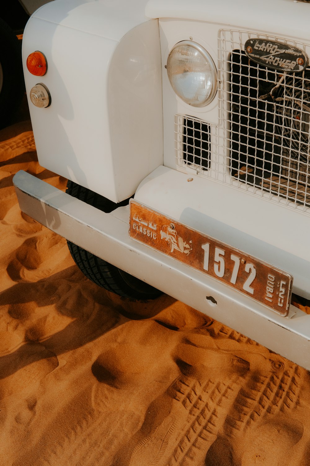 a white car with a license plate in the desert