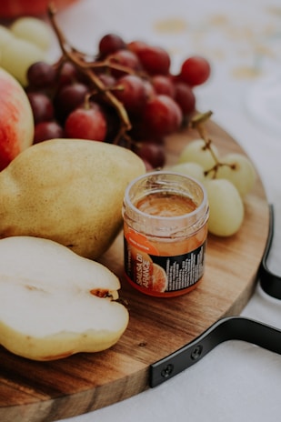 A rustic wooden board displaying an assortment of fresh fruit desserts with natural tones.