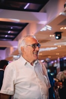 a man in a white shirt is smiling