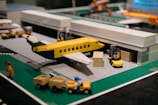 Detailed miniature airport terminal with tiny vehicles and planes.