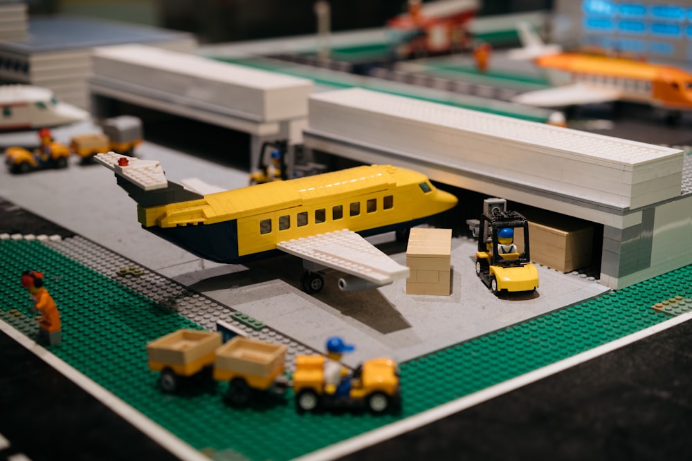 a lego model of a train station with a yellow plane