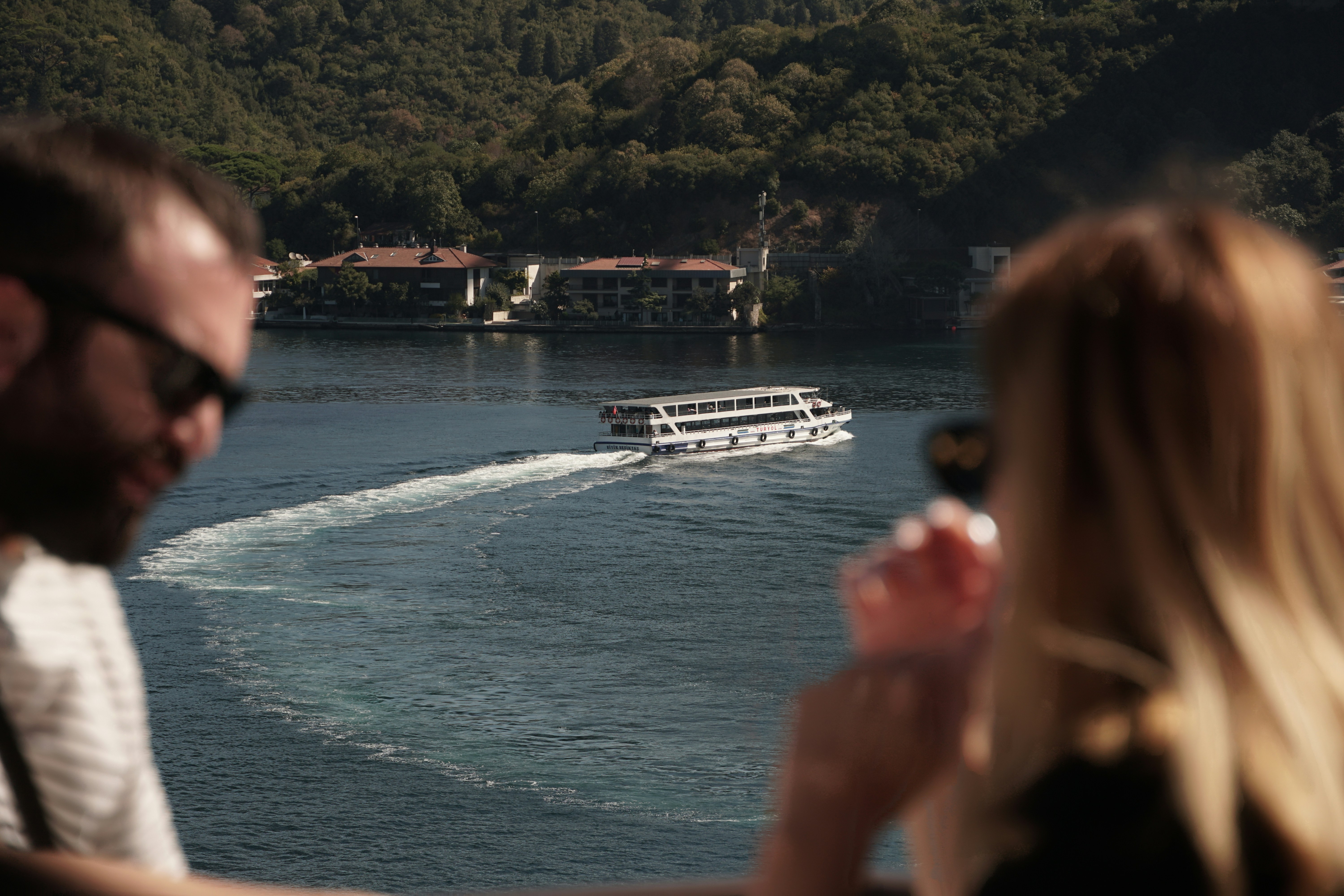 a man and a woman are looking at a boat in the water