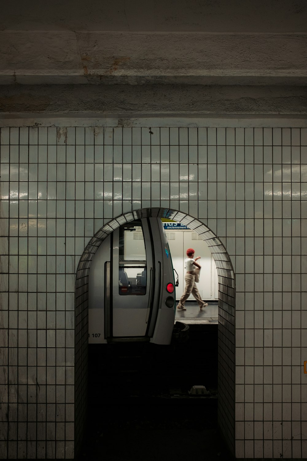 a subway station with a man walking through a tunnel