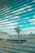 A surveillance camera is mounted on a pole overlooking a rooftop area. The scene is viewed through a set of horizontal blinds, creating a striped pattern across the image. The sky is visible in the background with scattered clouds.