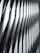 The image features a modern architectural facade with a geometric, repeating pattern of overlapping and protruding panels. The design creates a sense of depth and dynamism, with sharp angles and shadows accentuating the three-dimensional effect.