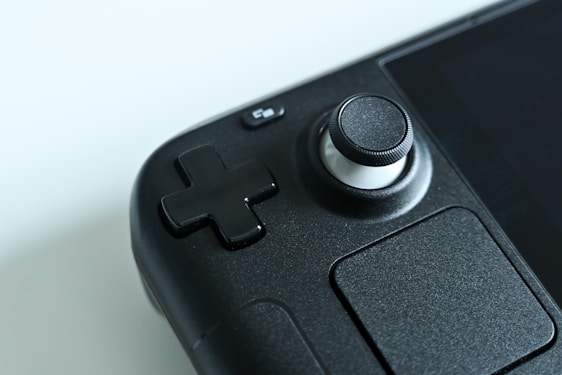 A close-up of a portable gaming console on a wooden table.