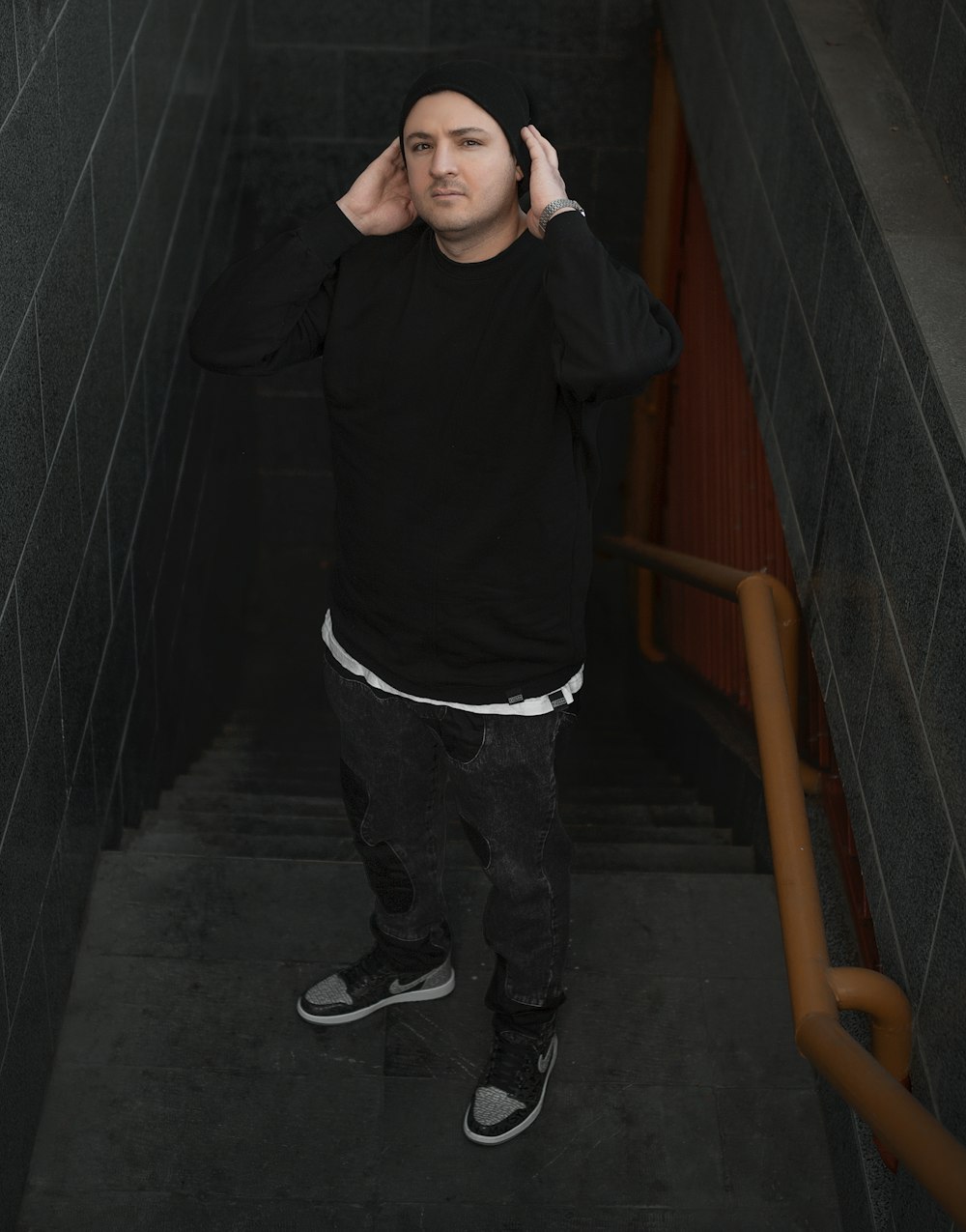 a man standing in a stairwell with his hand on his head