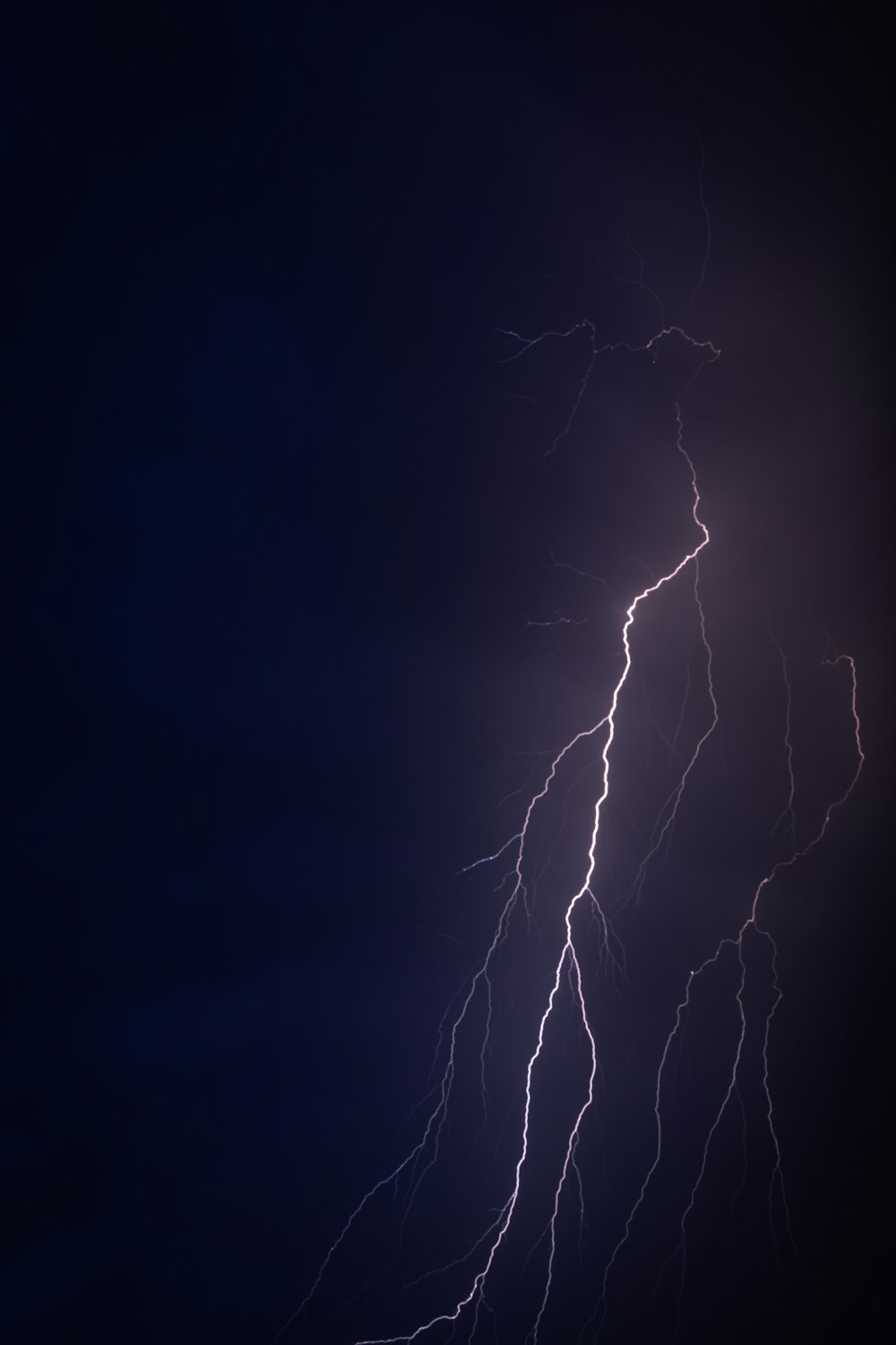 a lightning bolt is seen in the dark sky
