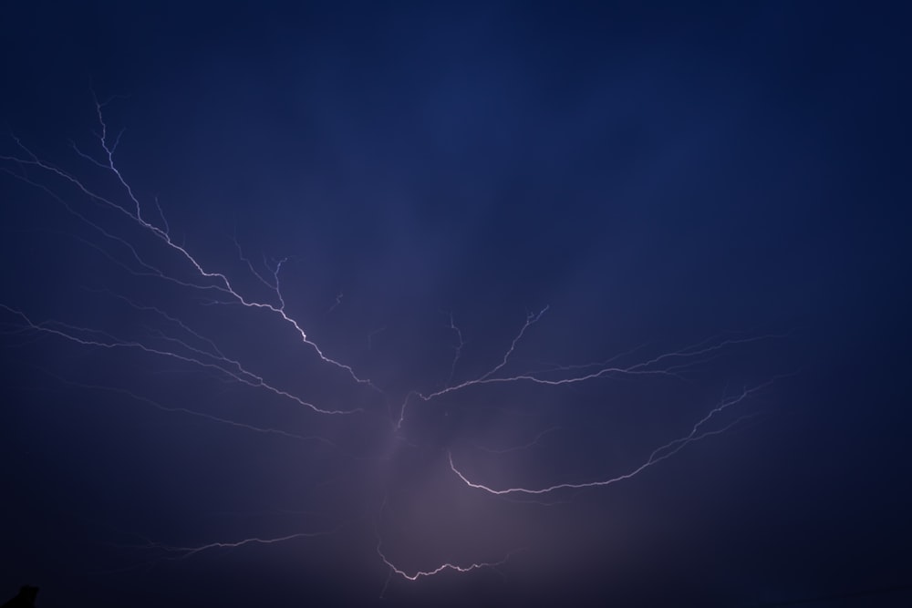 a lightning strike is seen in the night sky