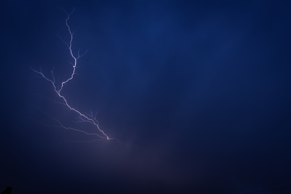 a lightning bolt is seen in the dark sky