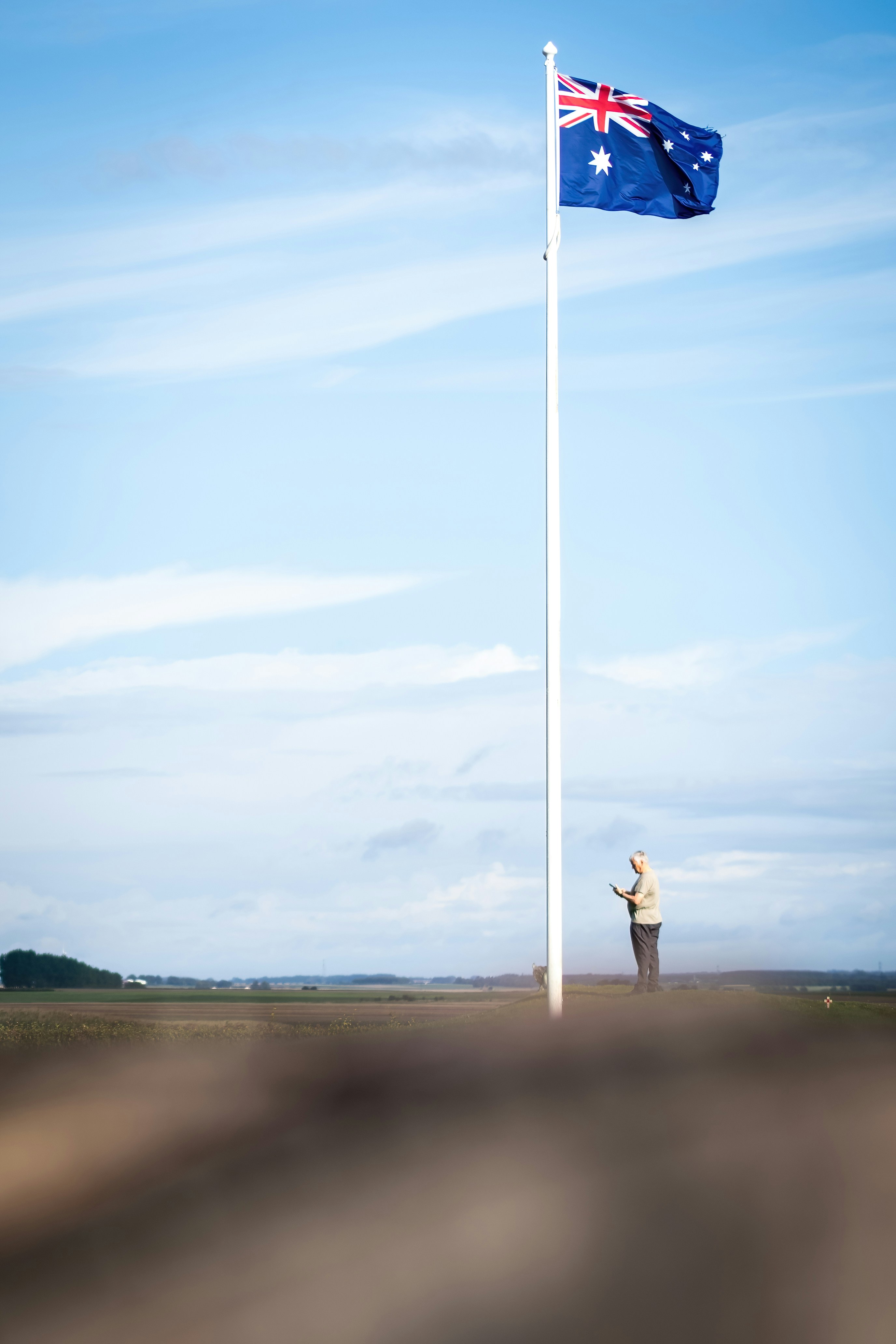 a man standing next to a flag on top of a field