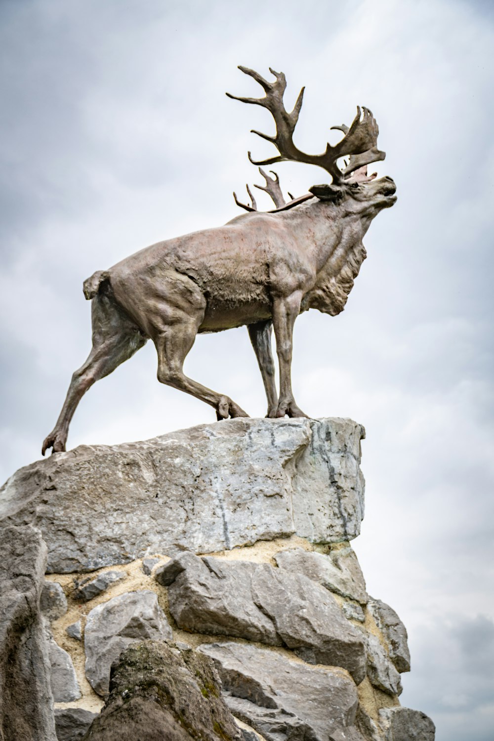 a statue of a deer standing on top of a rock