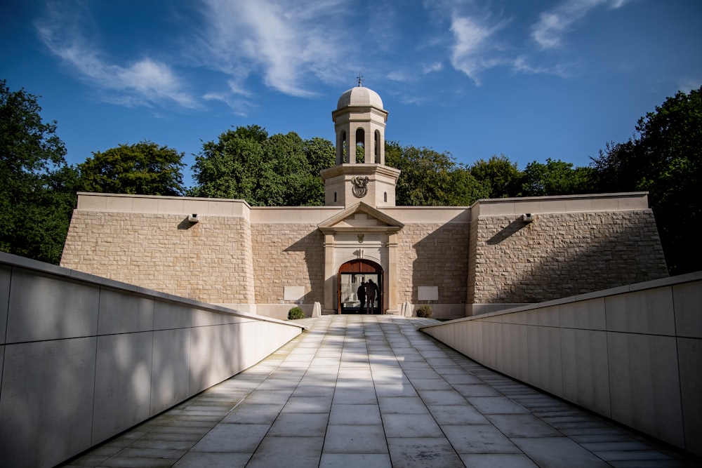 a walkway leading to a building with a clock tower