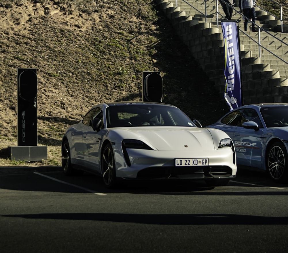 two white sports cars parked next to each other