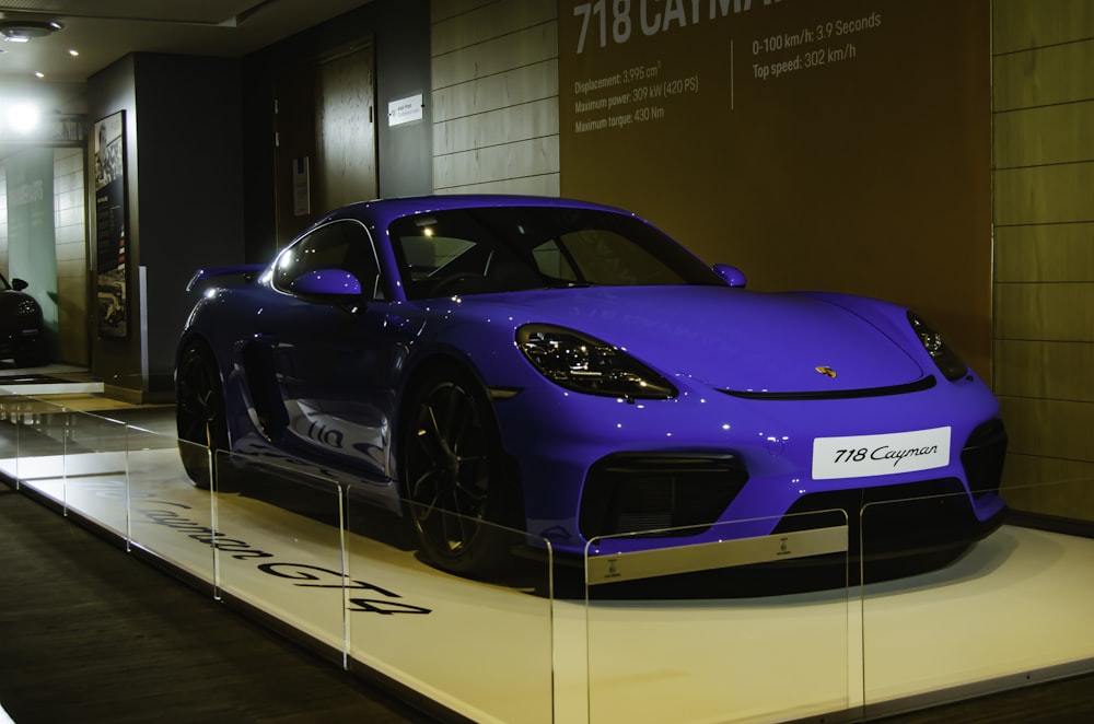 a blue sports car on display in a building