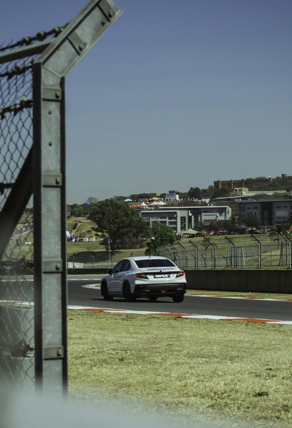 a white car driving down a race track