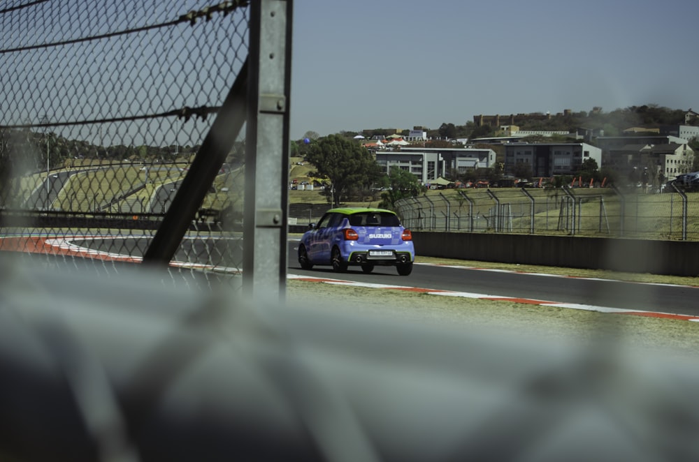 a blue car driving down a race track