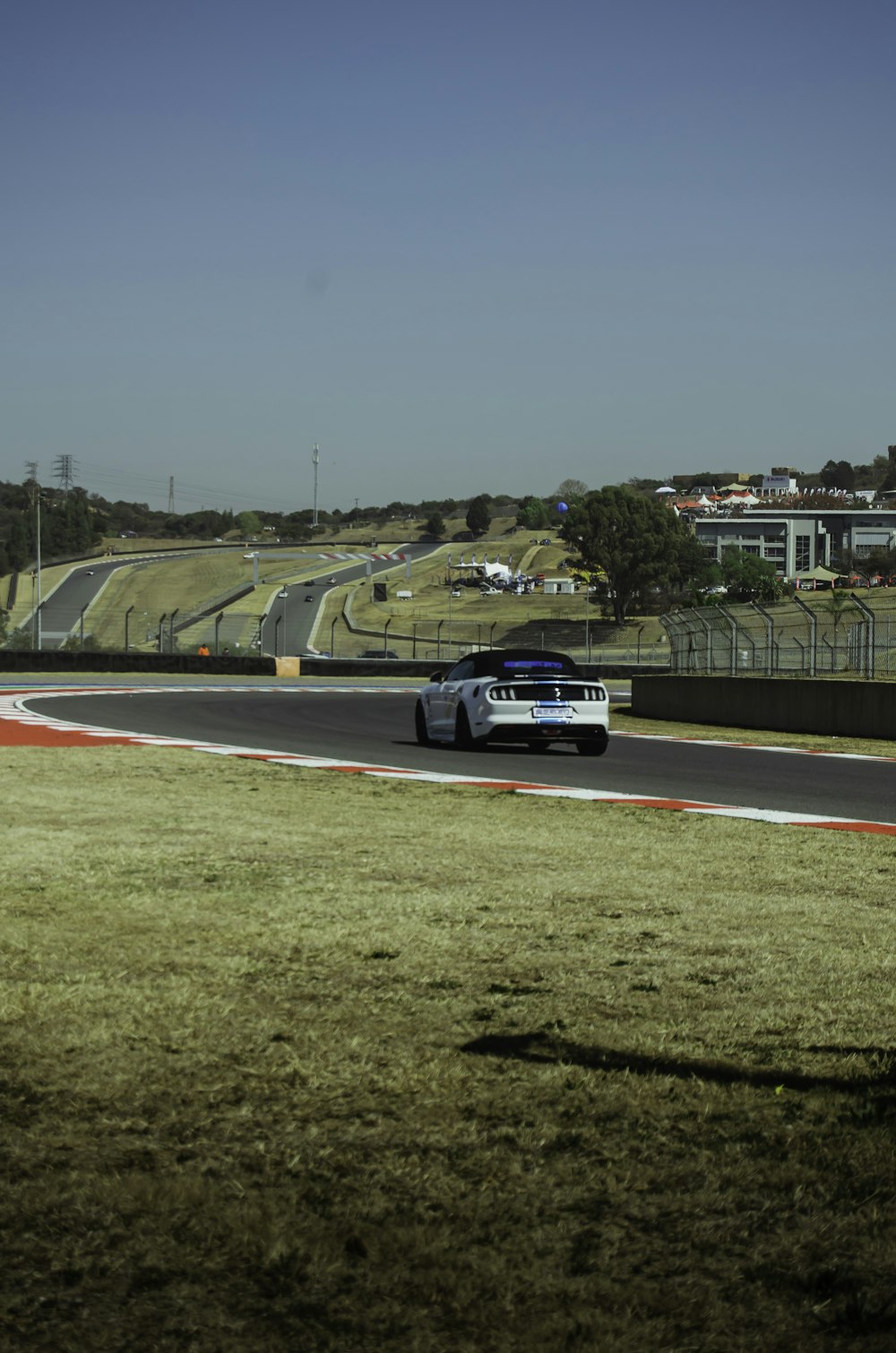 a white car driving down a race track