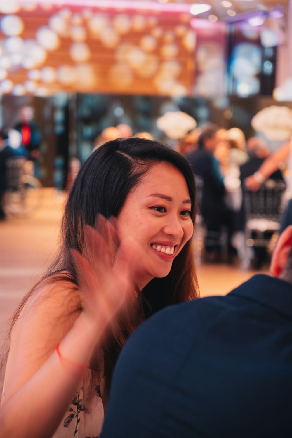 a woman sitting at a table with a smile on her face