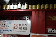 A display of Souzen branded vitamin bottles on a wooden shelf in a pharmacy.