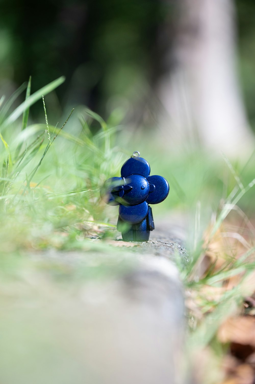 a small blue figurine sitting on top of a rock