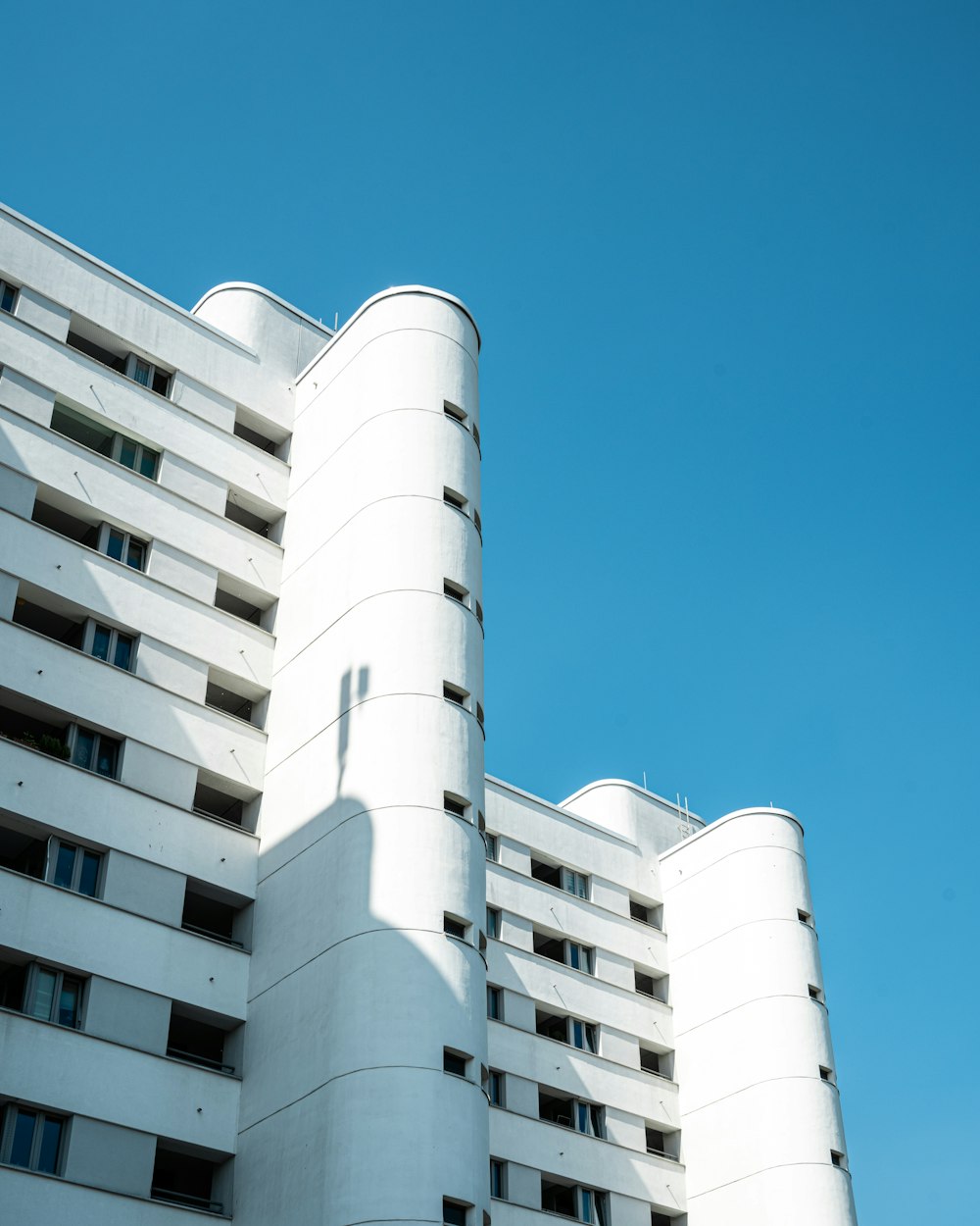 a tall white building sitting next to a blue sky