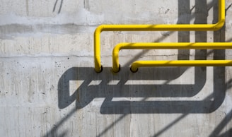 a yellow pipe on the side of a concrete wall