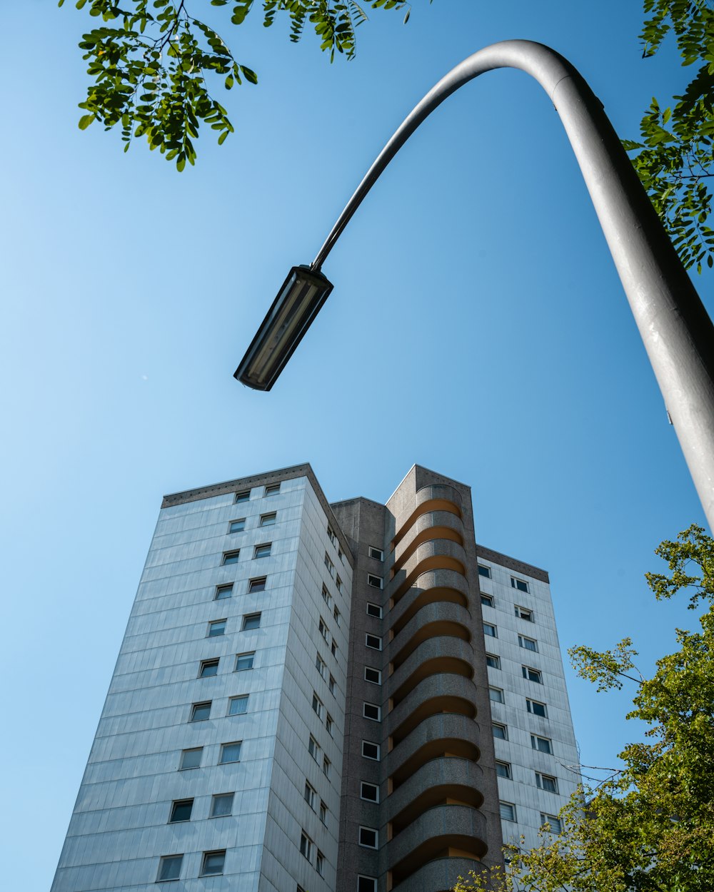 a tall white building sitting next to a street light