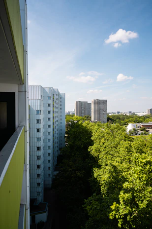 A serene view of Victoria Court Iyaganku's modern residential buildings surrounded by lush greenery under a clear sky.