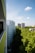 A serene view of a modern apartment balcony overlooking a vibrant city skyline at sunset.