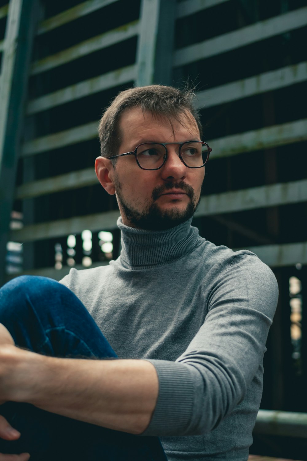 a man with glasses sitting on the ground