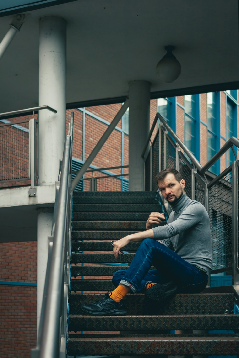 a man sitting on a stair case talking on a cell phone