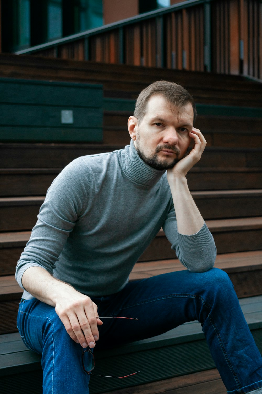 a man sitting on a bench in front of some stairs