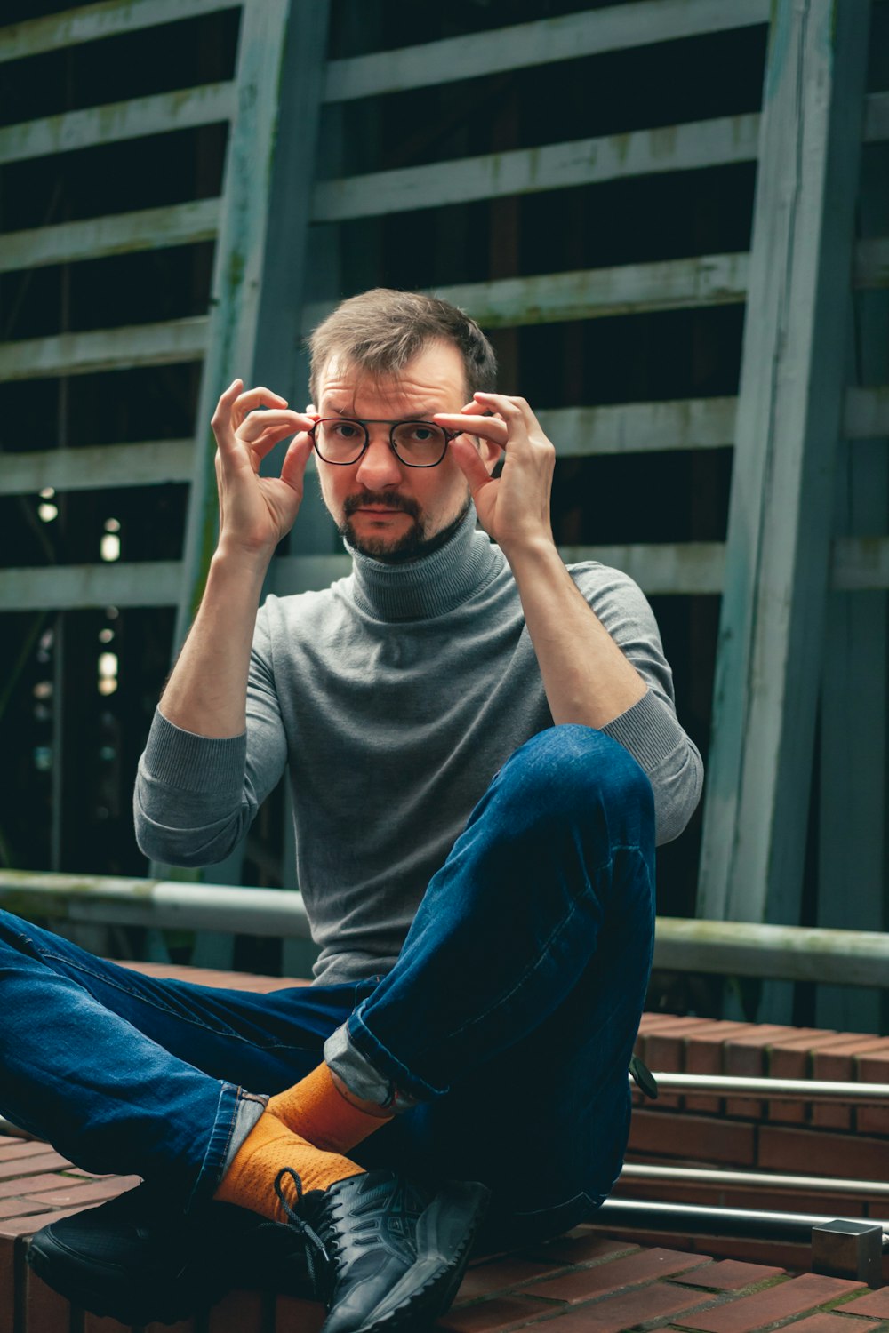 a man sitting on a bench wearing glasses