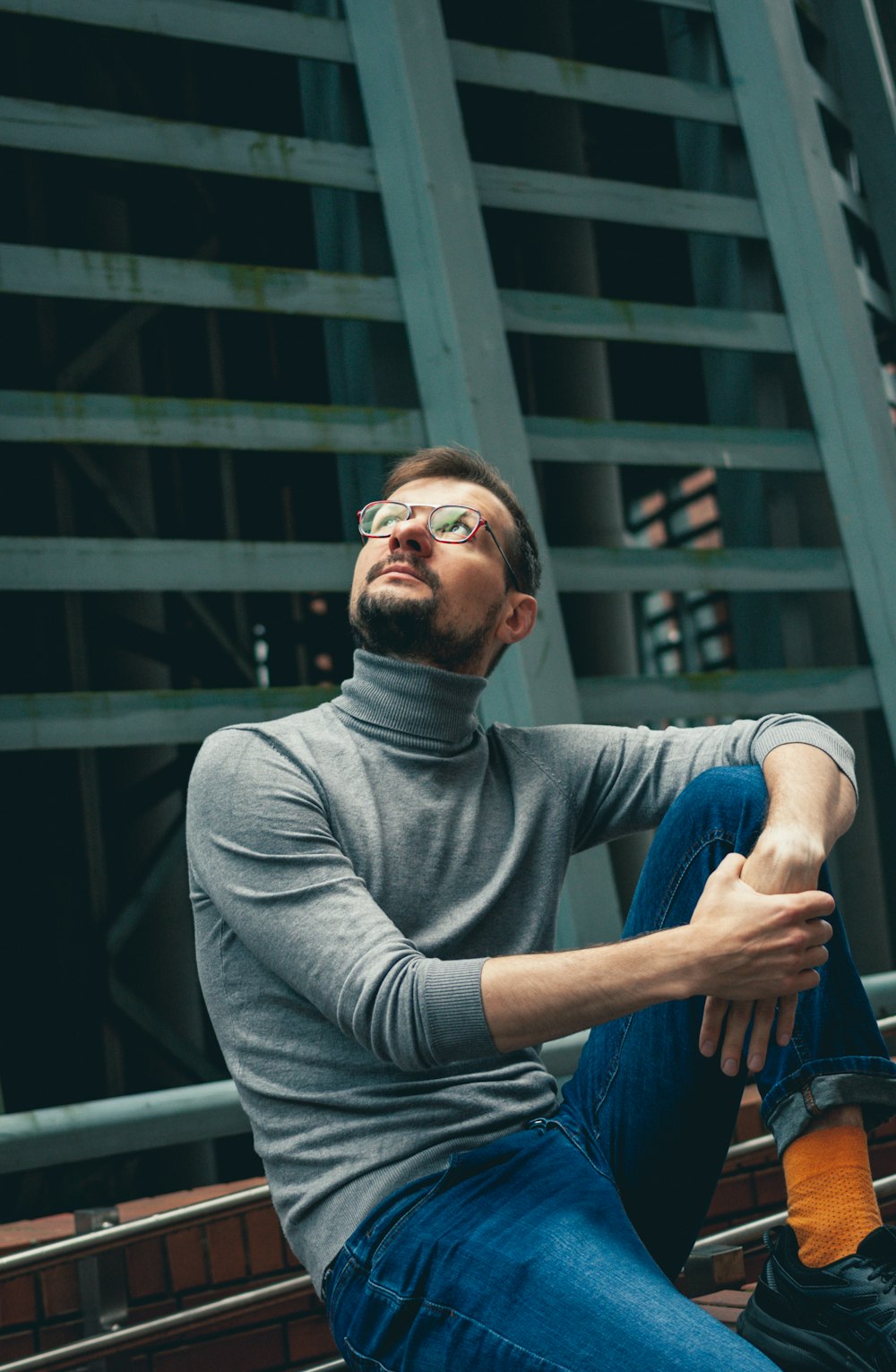 a man sitting on a bench with his legs crossed