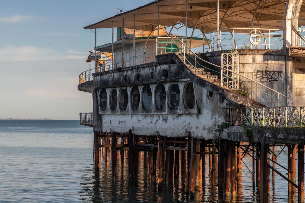 an old building sitting on top of a pier next to the ocean