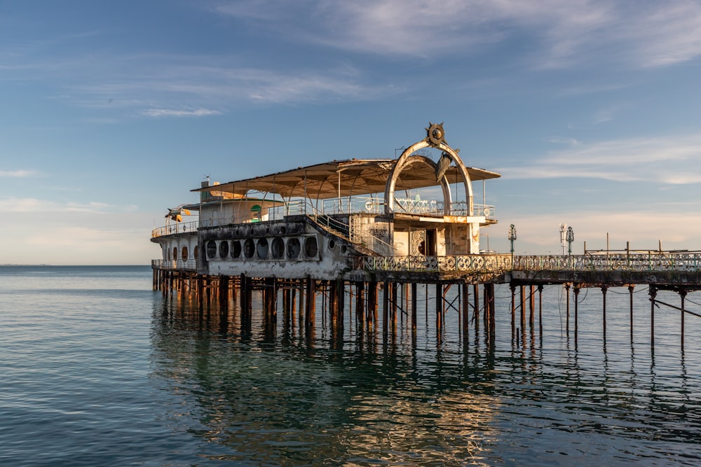 a pier with a building on it in the middle of the water