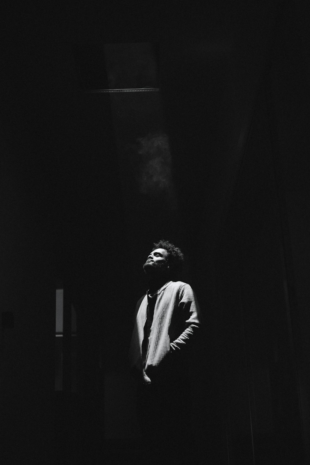 Una foto en blanco y negro de un hombre fumando un cigarrillo