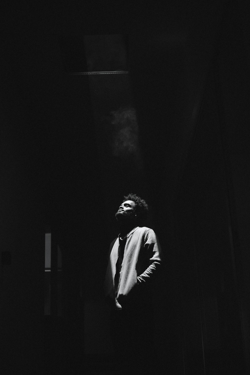 a black and white photo of a man smoking a cigarette