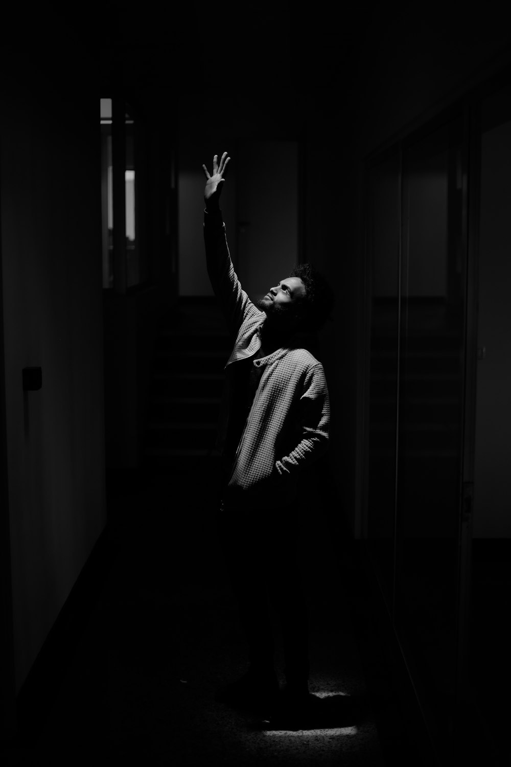 a person standing in a dark room reaching up