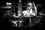 A sleek motorcycle parked on a futuristic city street at night.