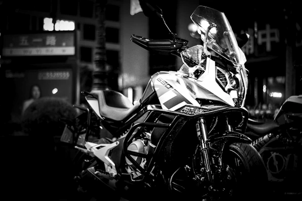 A sleek motorcycle parked under moody lighting highlighting its modern design.