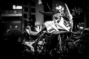A sleek modern motorcycle equipped with the Veloguard GPS device glowing softly at dusk.