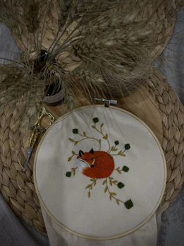 Close-up of a delicate fabric fox with embroidered details on natural linen.
