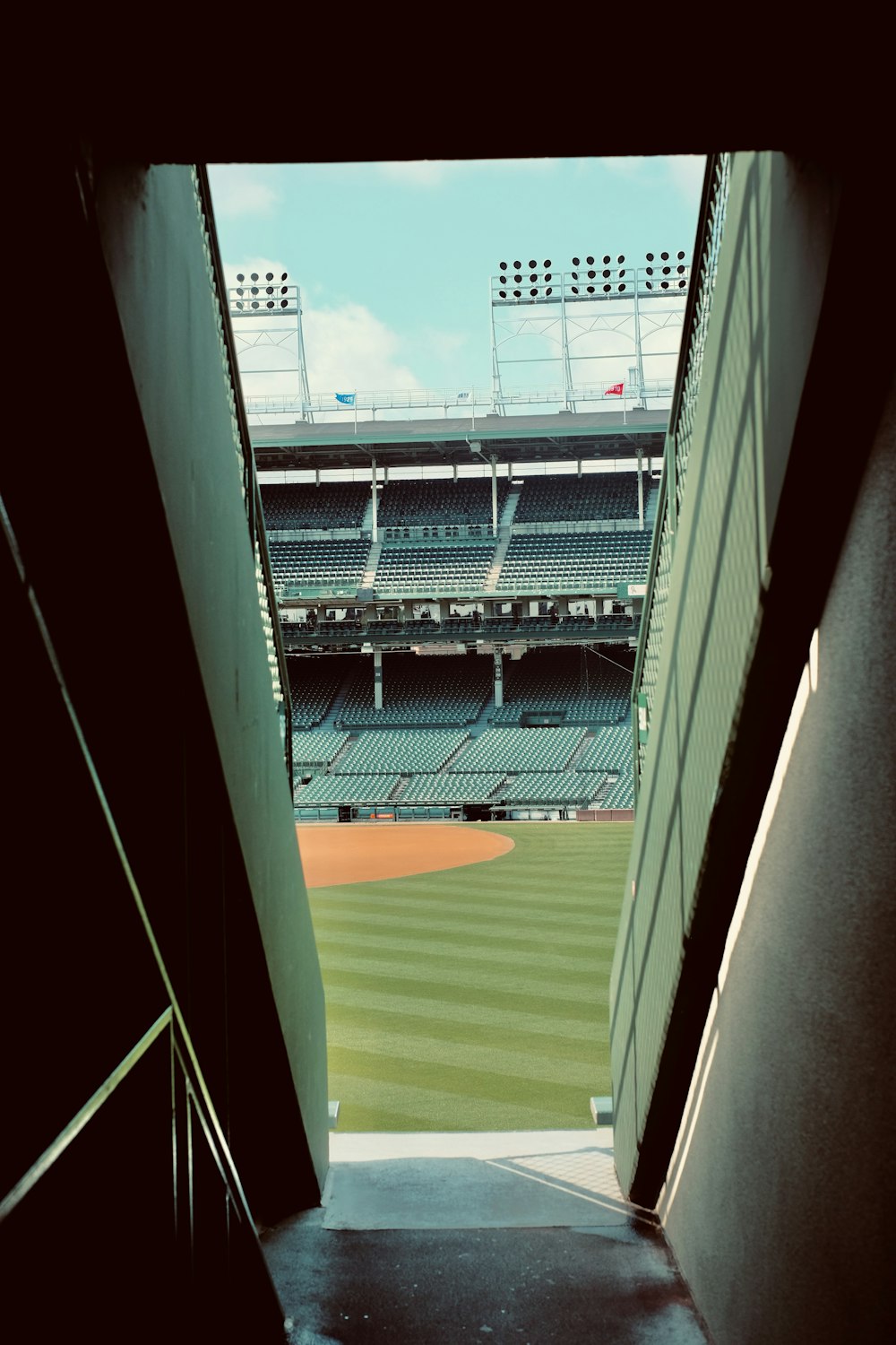 a view of a baseball field from the bottom of a flight of stairs