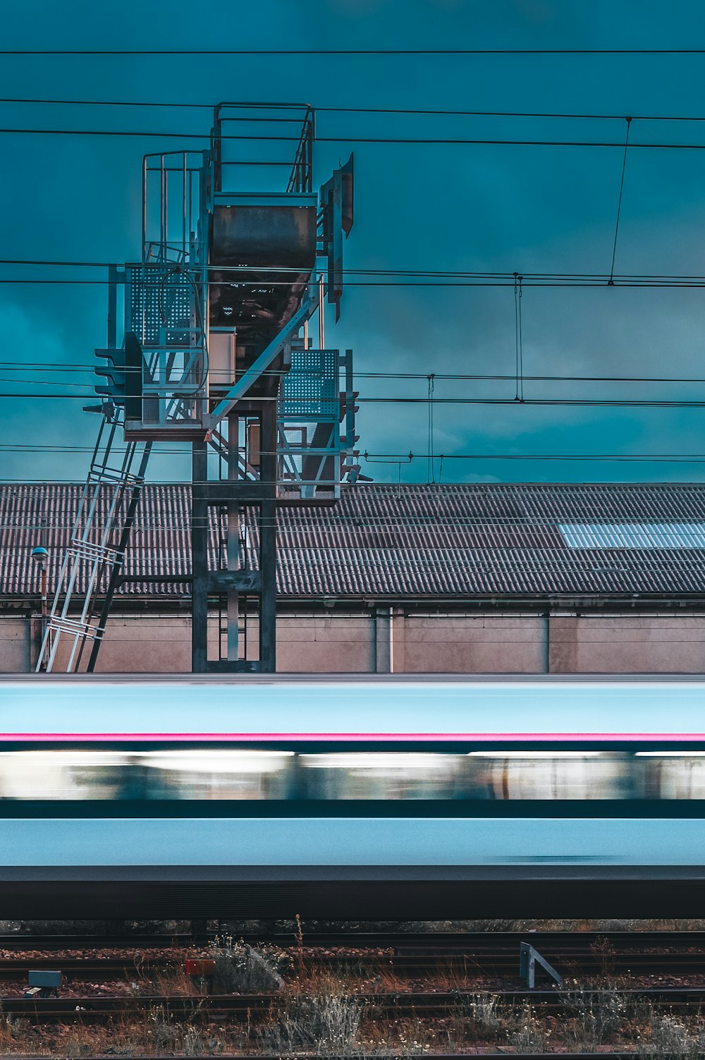 a white train traveling past a tall building