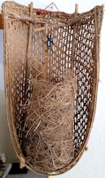 Rustic wooden basket filled with bundles of natural fibers ready for processing.