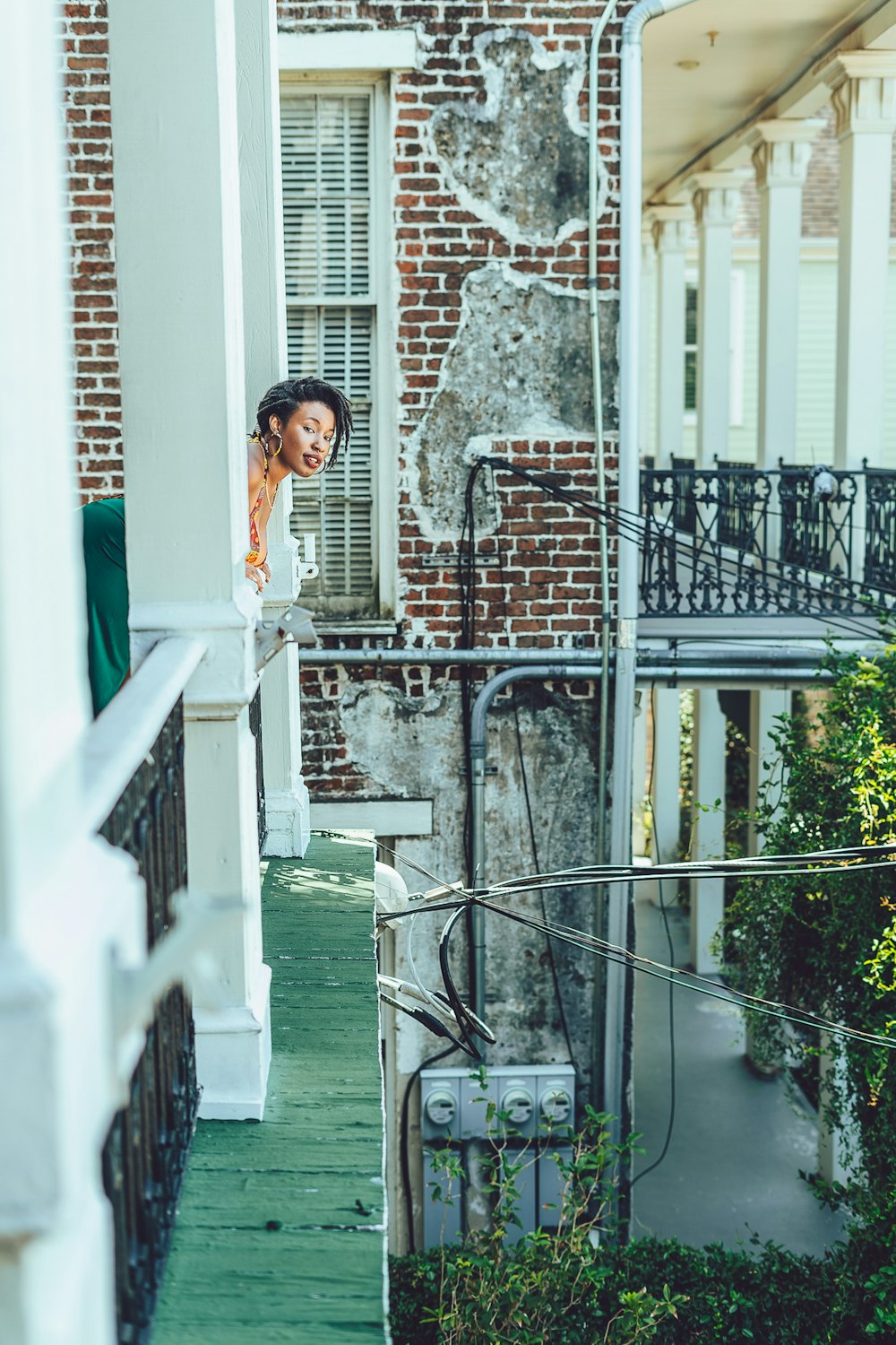 a woman standing on a porch next to a building