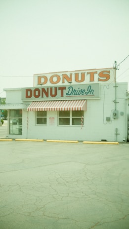 A vibrant food trailer with a cheerful sign serving mini donuts.