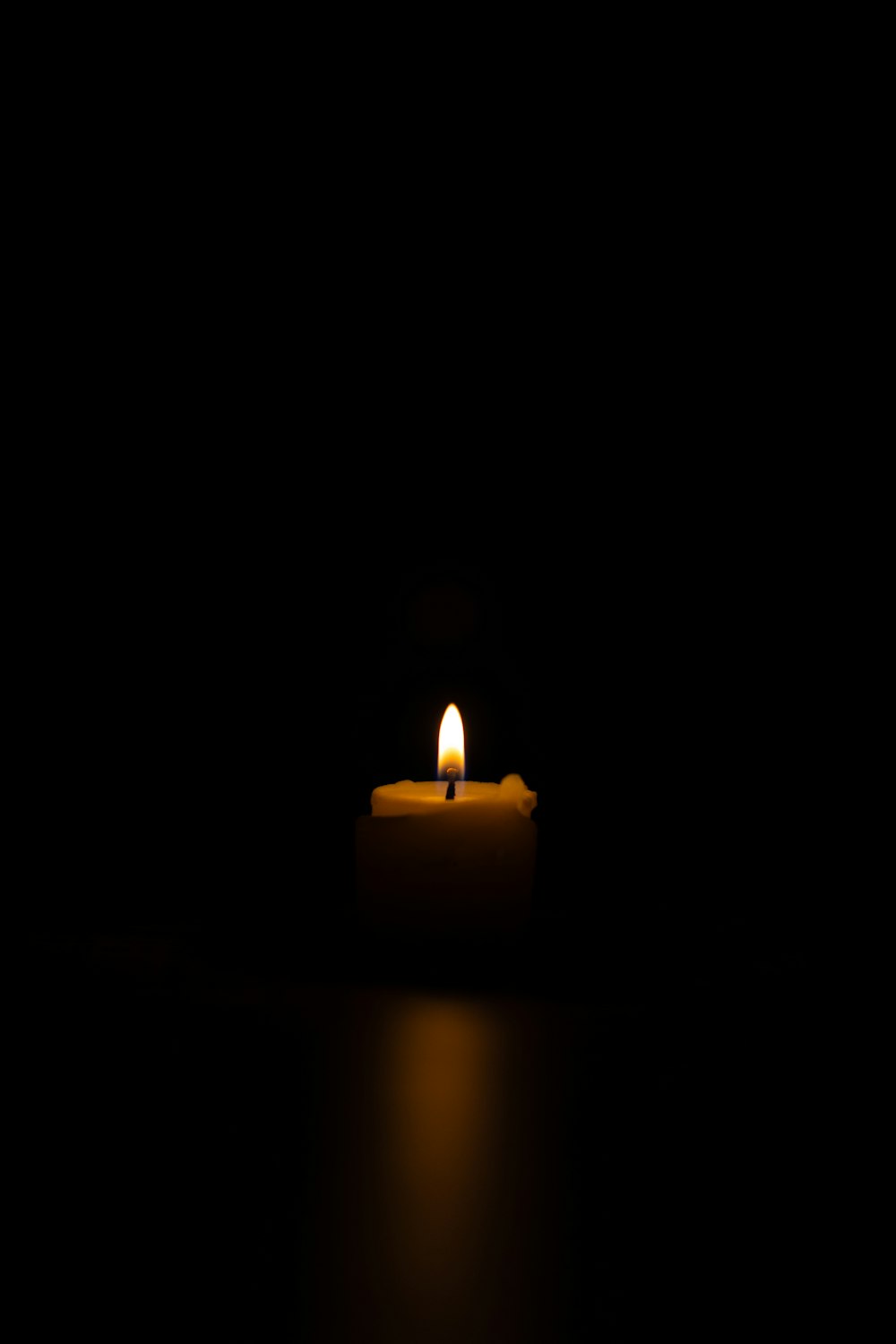 a lit candle sitting on top of a table